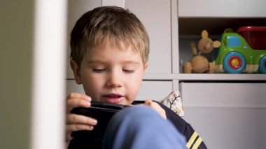 Aletle ilgili çocuk sorunları. Küçük çocuk akıllı telefondan oyun oynuyor. Çocuk akıllı telefon kullanıyor. Çocuk telefonda video oyunu oynuyor. Çocuklar alet kullanırdı. Alfa kuşağı. Cep telefonu çalan bir çocuk. Yeni nesil