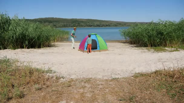 Dad chasing kid having fun enjoy leisure activity laughing spend time together in local hike travel. Funny child son and father quickly run around tent catch up playing touch and play tag game outdoor — Stock Video