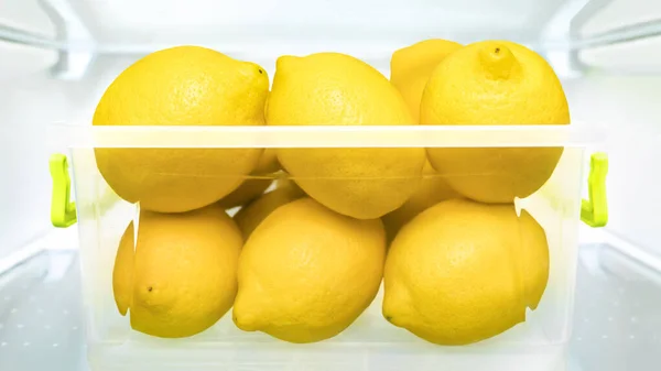 Food storage containers lemons refrigerator healthy eating fresh fruits fridge stocking vitamin C immune system boosters. Cool lemon fridge lemonade detox juice ripe fruit in plastic box refrigerator