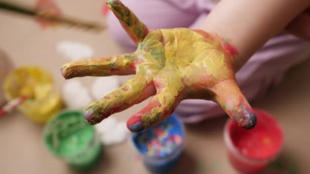 Renkli boyalı kız bebek ressamının çocuk eli çizimi yaratıcı çocuk eğitimi. Bebek parmak boyası, el boyası, el sanatı, bebek. Çocuk el fırçasını boyuyor. Bebek avuç içini yakın. — Stok video