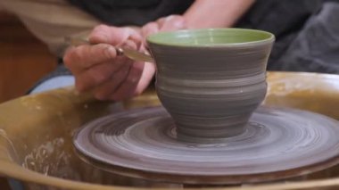 Kil çömlek üzerinde çömlek resmi. El yapımı seramik. Toprak takımı. Çömlekçilik sınıfındaki çömlek atölyesinde boya fırçasıyla seramik kap boyamak. Potter, çanak çömlek boyama işini halleder.