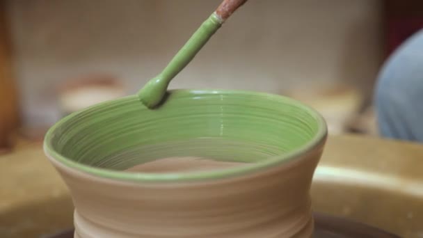 Pottery painting on clay pot. Handmade workshop ceramic. Earthenware. Painting ceramic pot with paint brush in pottery class potter workshop wheel. Potter work hands close up painting pottery making — Stock Video