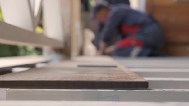 Instalación de suelos una terraza. Carpenter dibuja una línea de corte en tablón de madera. Cierre las tablas del suelo de medición con regla de esquina. El carpintero con lápiz y marcas de metro miden sobre tabla de madera. Reparación casa — Vídeos de Stock