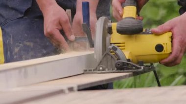 Elektrikli testereyi kapat. Marangoz ahşap panel kesiyor. Zanaatkar elektrikli testereyle tahtayı keser. Joiner dairesel testere üzerinde çalışıyor. Tamirhane. Marangozluk aletleri. Mobilya üretimi