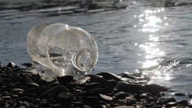 Çöpe atılmış plastik nehir atıkları. Doğanın ekolojik kirliliği. Çevresel sorunlar nehir kirliliği çöplük su çöpü. Boş şişe plastik çöpü nehir kıyısındaki su atığında yatıyor.
