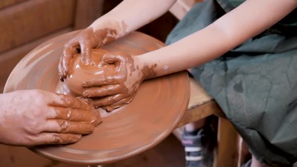 Close up ruce keramika kolo pot hliněný hrnčíř dítě řemeslo. Keramický umělec ruční keramika kolo pot hlína dítě tvůrčí workshop. Mentoring kids art education. Učím dítě. Kola hrnčíř ruční jíl tvarování — Stock video