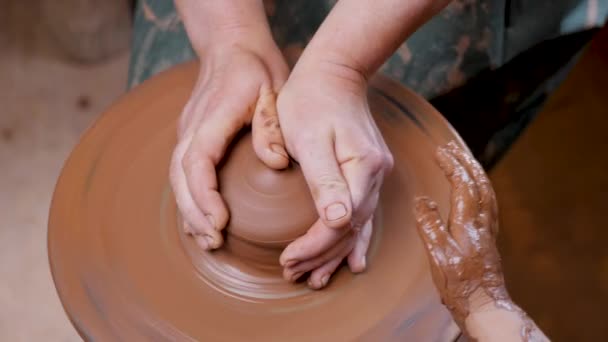 Fermer mains poterie pot de roue potier argile enfant artisanat éducation artistique. Artiste céramique poterie main pot roue argile enfant atelier créatif. La motricité fine. Vue du dessus potier de roue façonnage de l'argile main — Video
