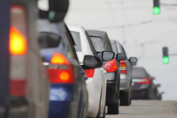 Trafik sıkışıklığında arka plandaki şehir trafiği bulanık. Bulanık trafik sıkışıklığı arka planda şehrin buzları çözüldü. Trafik sıkışıklığı. Kalabalık arabalar yolda yavaş ilerliyor. Şehir bulanıklığı.