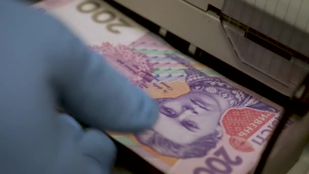 Ukrainian banknotes in currency counting machine recounts cash hryvnias money UA banknotes. Counting hryvnias banknotes. Closeup cash Ukrainian money counting machine calculating 200 hryvnias bills UA — Stock Video