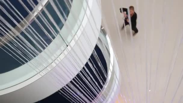 Photographer taking photo real estate interior design contemporary architecture inside hotel hall wall water fountain. Artificial waterfall jets flows down from ceiling decorative fountain in interior — Stock Video