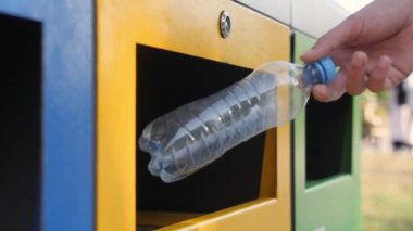 Boş şişe. Plastik çöp tenekesi. Şişeyi geri dönüşüm kutusuna koy. İnsan atığı geri dönüşüm kutusu. Erkek eli plastik şişe fırlatma çöp konteynırını çöp toplama kutusunu düzenleme