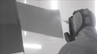 Endüstriyel boya, metal tozu kaplama boya üretim süreci. Metal ürünlerin toz tabakası. Parça parça metal atölyesini sprey tabancayla boyayan kapak çalışanı. Metal işçiliği fabrika boyası