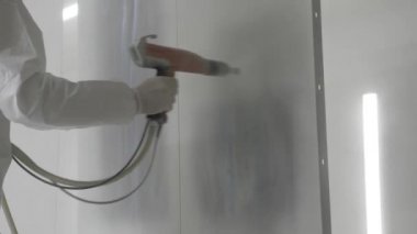 Endüstriyel boya, metal tozu kaplama boya üretim süreci. Metal ürünlerin toz tabakası. Parça parça metal atölyesini sprey tabancayla boyayan kapak çalışanı. Metal işçiliği fabrika boyası