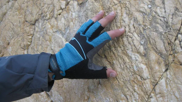 A hand in a sports glove touches a rock. Rock climbing. Mountaineering. — Fotografia de Stock