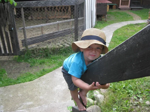 Menino em umas férias de chapéu de palha na aldeia — Fotografia de Stock