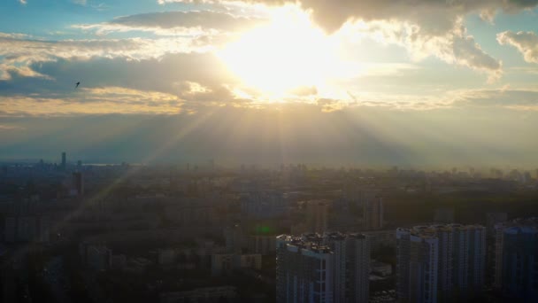 Вид с воздуха на город в лучах яркого солнца на закате — стоковое видео