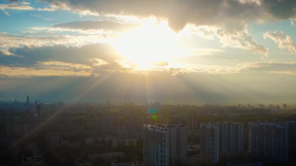 Luchtfoto van de stad in de stralen van de felle zon bij zonsondergang — Stockvideo