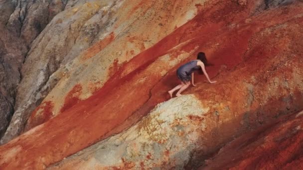 Vista aérea de una chica que sube las montañas rojas en un vestido — Vídeos de Stock