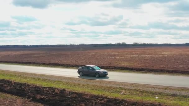 映画の鳥の目のビュー:車は黄色のフィールド上の大まかな地形上に駆動します. — ストック動画