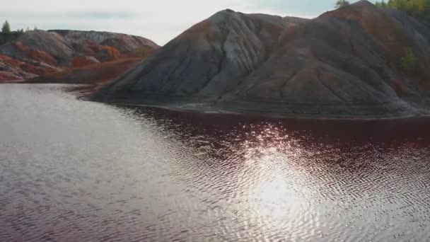 Вид з повітря на пейзаж схожий на планету Марс з червоними пагорбами і річками з червоною водою — стокове відео