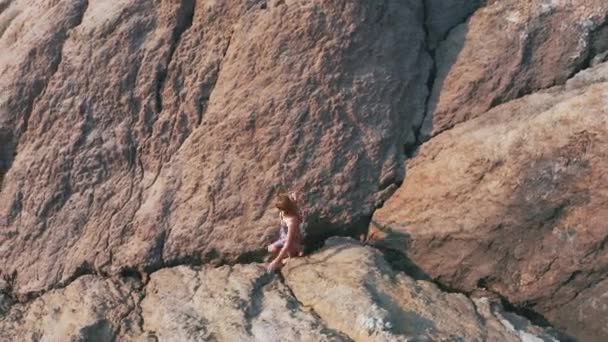 Vista aérea de una chica que sube las montañas rojas en un vestido — Vídeos de Stock