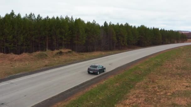 Pohled z ptačí perspektivy: auto projíždí nerovným terénem na žlutém poli. — Stock video
