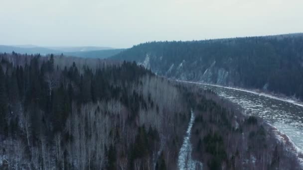 Widok z powietrza na zimną rzekę, skały i las wczesną zimą — Wideo stockowe