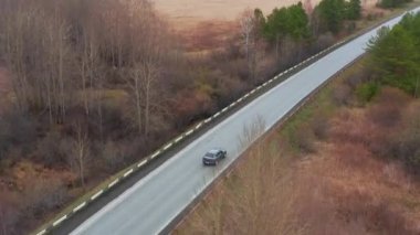 Sinema kuşbakışı manzara: bir araba sarı bir arazide engebeli arazide sürüyor.