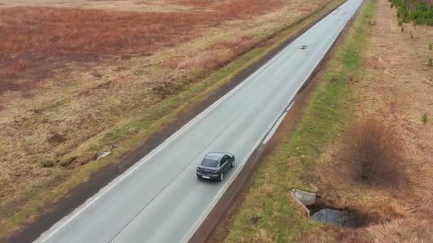 Vista panoramica sugli uccelli cinematografici: un'auto guida su terreni accidentati su un campo giallo. — Video Stock