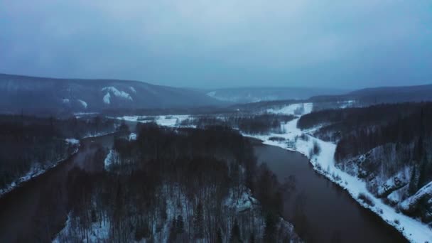 河岸上有丘陵和雪地的河流的空中景观 — 图库视频影像