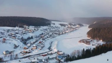 Kışın gün batımında parlak güneşle köyün hava manzarası