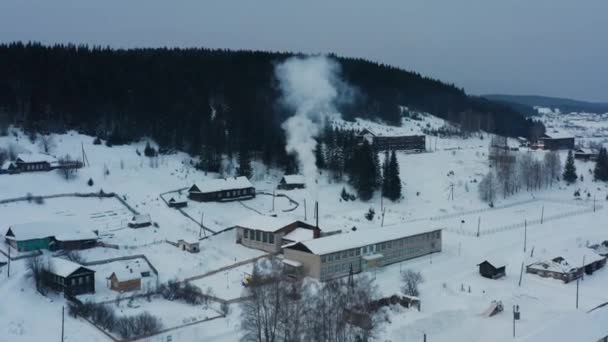 Flygfoto av rök kommer från kaminer i trähus i byn på vintern — Stockvideo