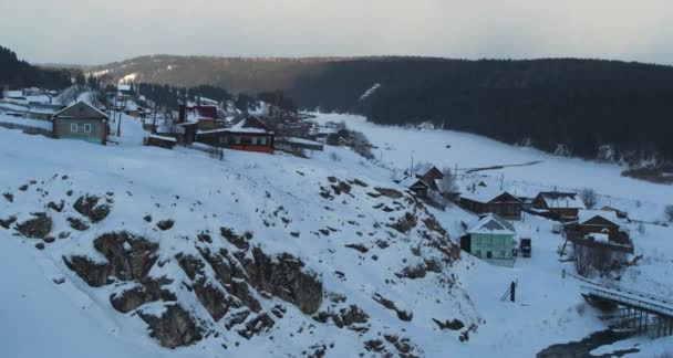 Luchtfoto van het huis aan de rand van de klif in de winter in het dorp bij zonsondergang — Stockvideo