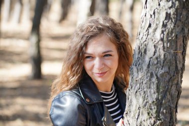 Tahtada poz veren çekici genç bir kadına yakın çekim. Ormanda dikilirken kameraya çekilen büyüleyici kadın.