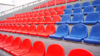 Spor stadyumundaki tribünler. Büyük bir stadyumda kırmızı ve mavi koltuklar.