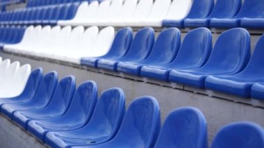 Spor stadyumundaki tribünler. Büyük bir stadyumda beyaz ve mavi koltuklar.