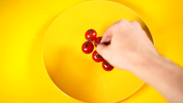 Спелые свежие органические помидоры черри на желтой тарелке. Красные помидоры черри на желтом текстурированном фоне. овощи и здоровое питание — стоковое видео