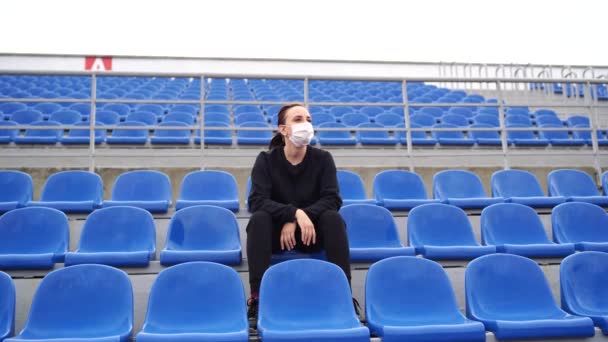 Egy Fiatal Fekete Melegítőben Hosszú Hajjal Stadionban Egyedül Egy Sportmeccset — Stock videók
