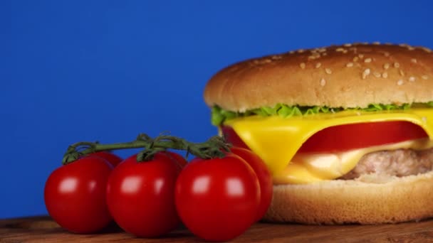 햄버거나 샌드위치요. 고기, 치즈, 신선 한 야채가 있는 맛있는 샌드위치 햄버거입니다. 햄버거 또는 샌드위치는 브런치나 점심을 위한 인기있는 패스트푸드이다. 쥬스 치즈 버거 — 비디오