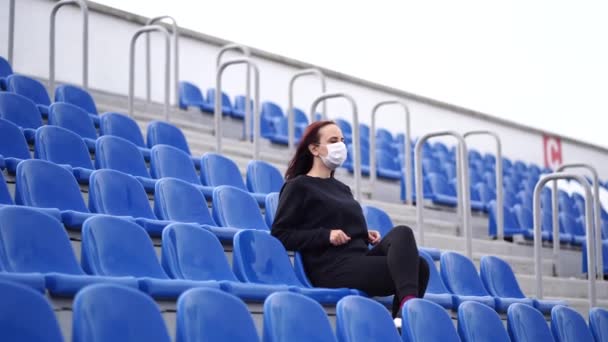 Mladá Žena Černé Teplákové Soupravě Dlouhými Vlasy Sedí Stadionu Stojí — Stock video