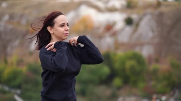 Junge Frau Beim Aufwärmen Hügeligem Gelände Erwachsene Frauen Schwarzer Freizeitkleidung — Stockvideo