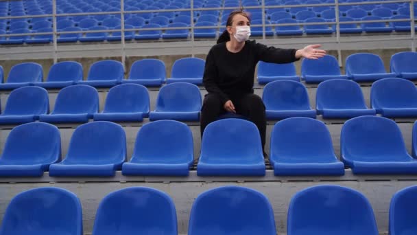 Молода Жінка Чорному Костюмі Довгим Волоссям Сидить Стадіоні Дивиться Спортивну — стокове відео