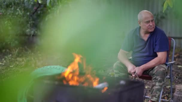 Starší Muž Sedí Židli Zahradě Starší Samec Zapálil Oheň Grilu — Stock video