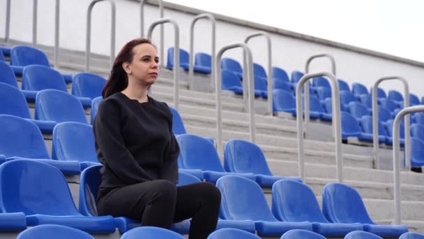Egy Fiatal Fekete Melegítőben Hosszú Hajjal Stadionban Egyedül Egy Sportmeccset — Stock videók