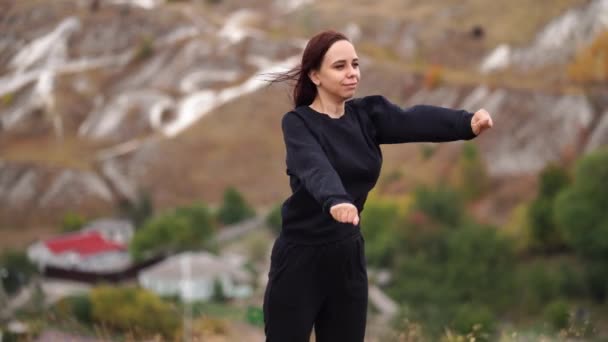 Junge Frau Beim Aufwärmen Hügeligem Gelände Erwachsene Frauen Schwarzer Freizeitkleidung — Stockvideo