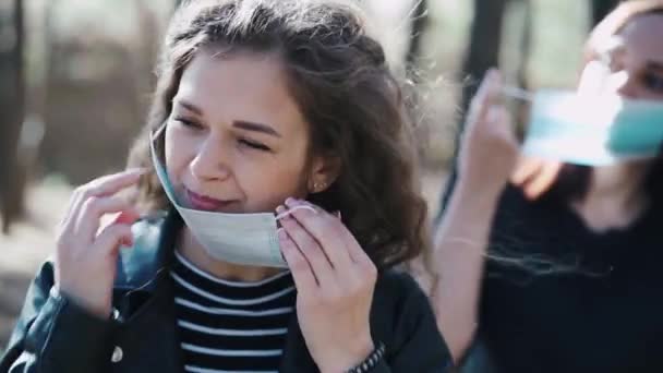 Dos Mujeres Jóvenes Poniendo Máscara Médica Cara Madera Acercamiento Las — Vídeos de Stock