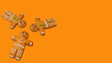 Turuncu arka planda zencefilli çörekleri yakın çekim yapın. Noel havası için süslü zencefilli çörekler ve bayramda klasik kurabiye kavramı.