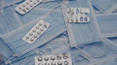 Koruyucu tıbbi maskelerin ve çeşitli tabletlerin çoğulculuğunu kapat. İnsan eli, içinde haplar ve koruyucu maske olan bir tıbbi su topladı. Önleme viral enfeksiyonu kavramı.