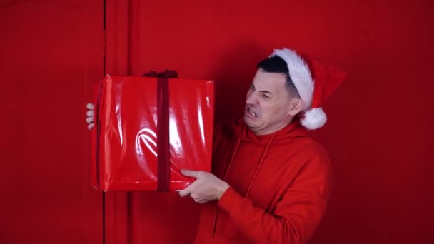 Young Man Santa Claus Hat Holds Heavy Big Gift Standing — Stock Video