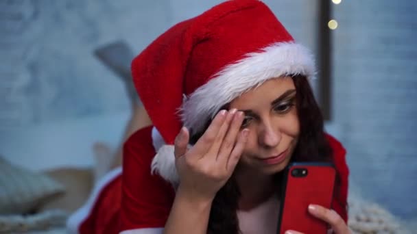 Giovane Donna Costume Babbo Natale Naviga Smartphone Sdraiato Sul Letto — Video Stock